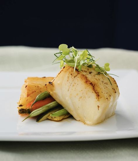 An individually plated entrée with vegetables and garnish