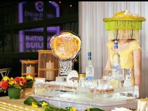 Yellow-themed event display with an ice bar and a costumed attendant